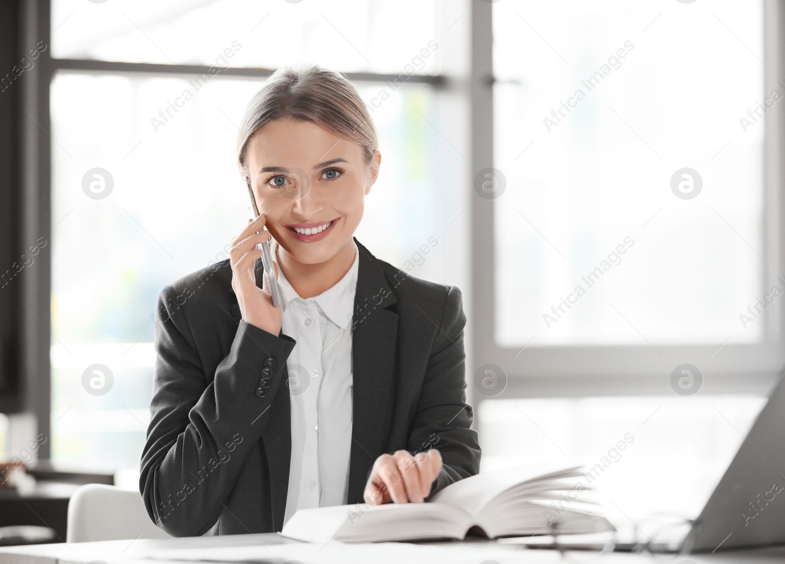 Photo of Female business trainer talking on phone in office