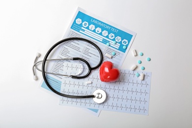 Composition with stethoscope and pills on white background. Cardiology service