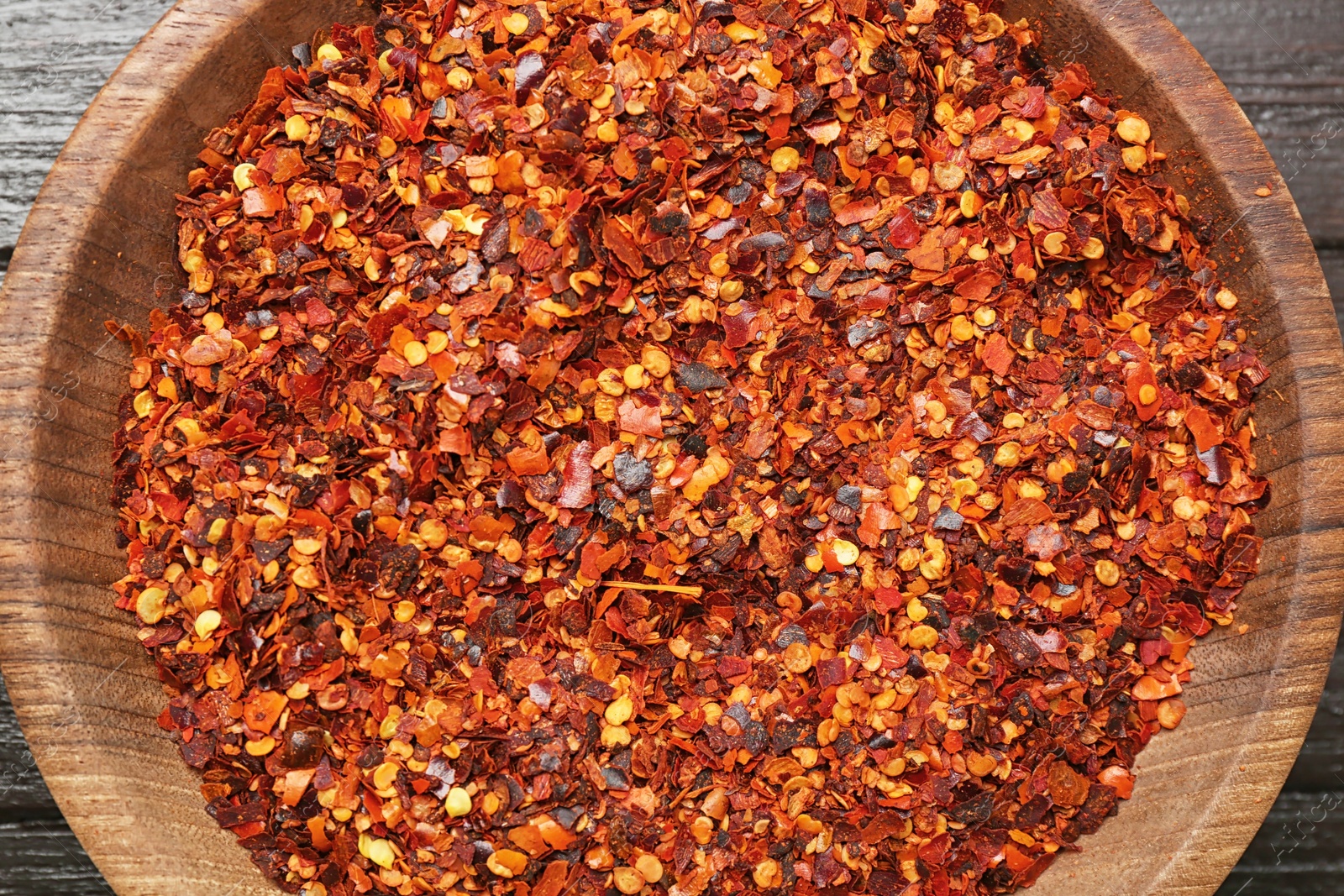 Photo of Plate with chili pepper flakes, top view