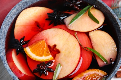 Tasty mulled wine with spices in cooking pot, closeup