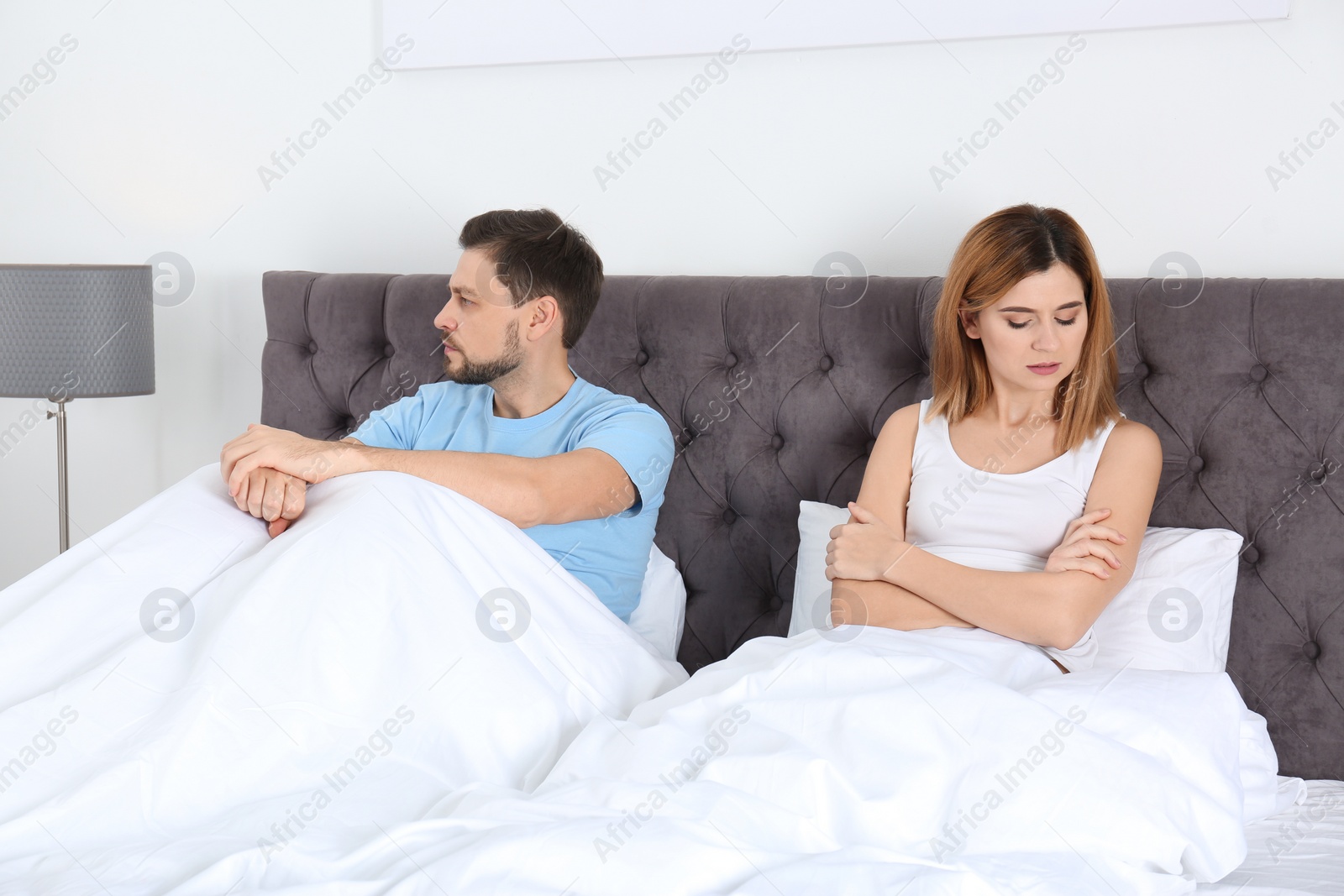 Photo of Couple with relationship problems ignoring each other in bedroom