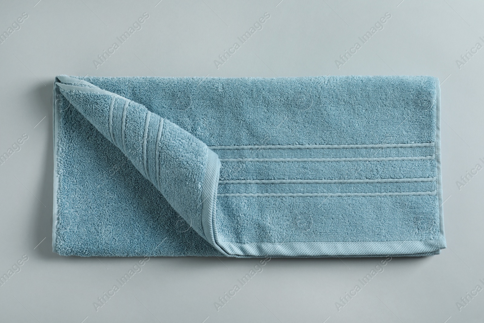 Photo of Fresh fluffy towel on grey background, top view. Mockup for design