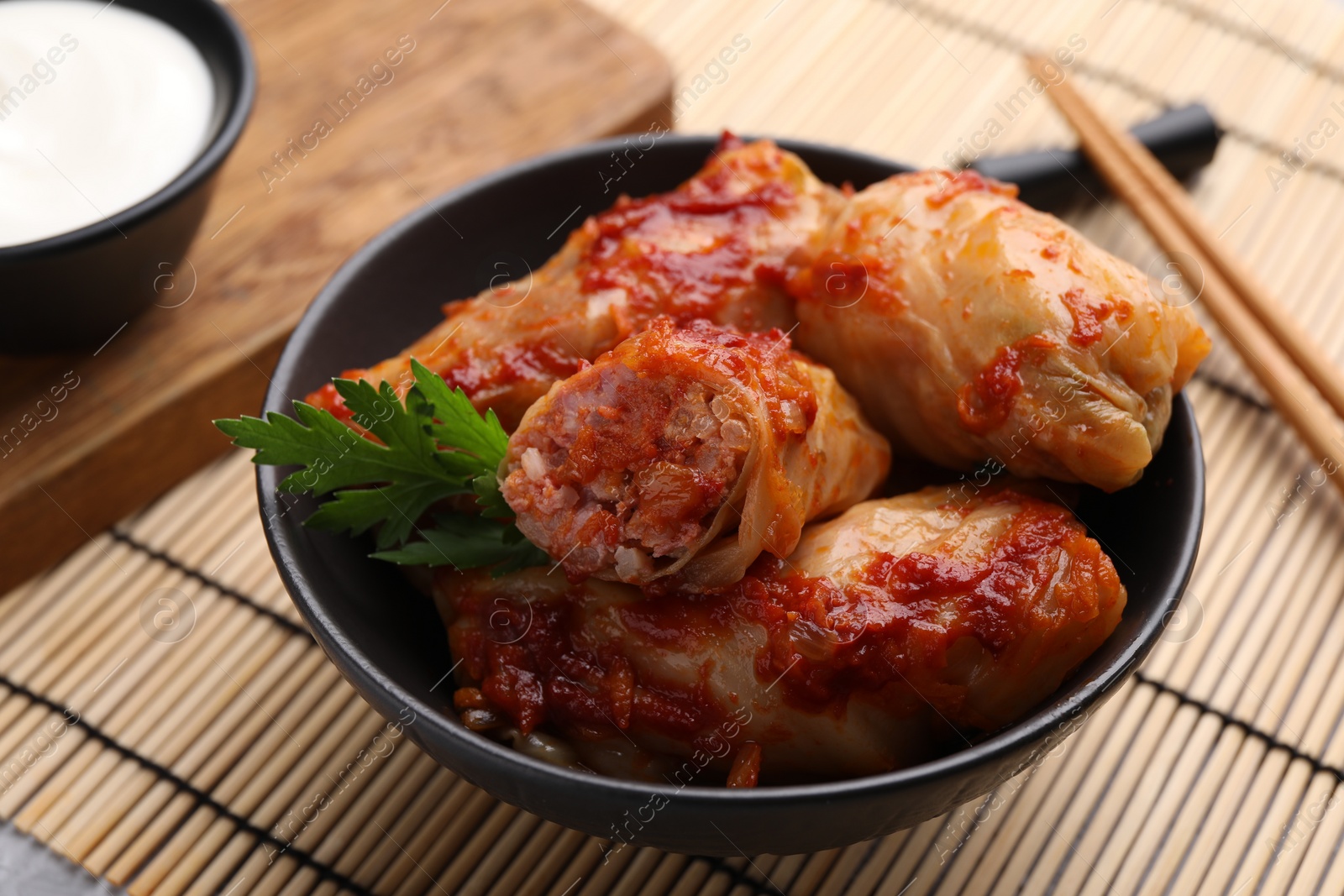 Photo of Delicious stuffed cabbage rolls cooked with homemade tomato sauce on table, closeup