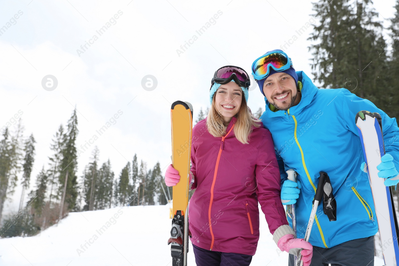 Photo of Couple of skiers on slope at resort. Winter vacation