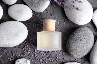 Photo of Flat lay composition with natural herbal oil and lavender flowers on grey background