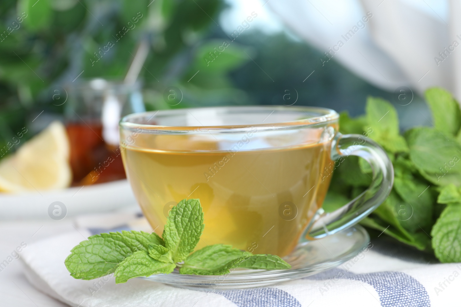 Photo of Fresh green tea with mint leaves on table, closeup