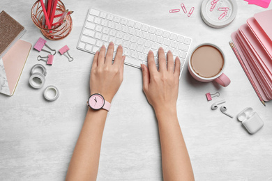 Female designer working with computer at white table, top view