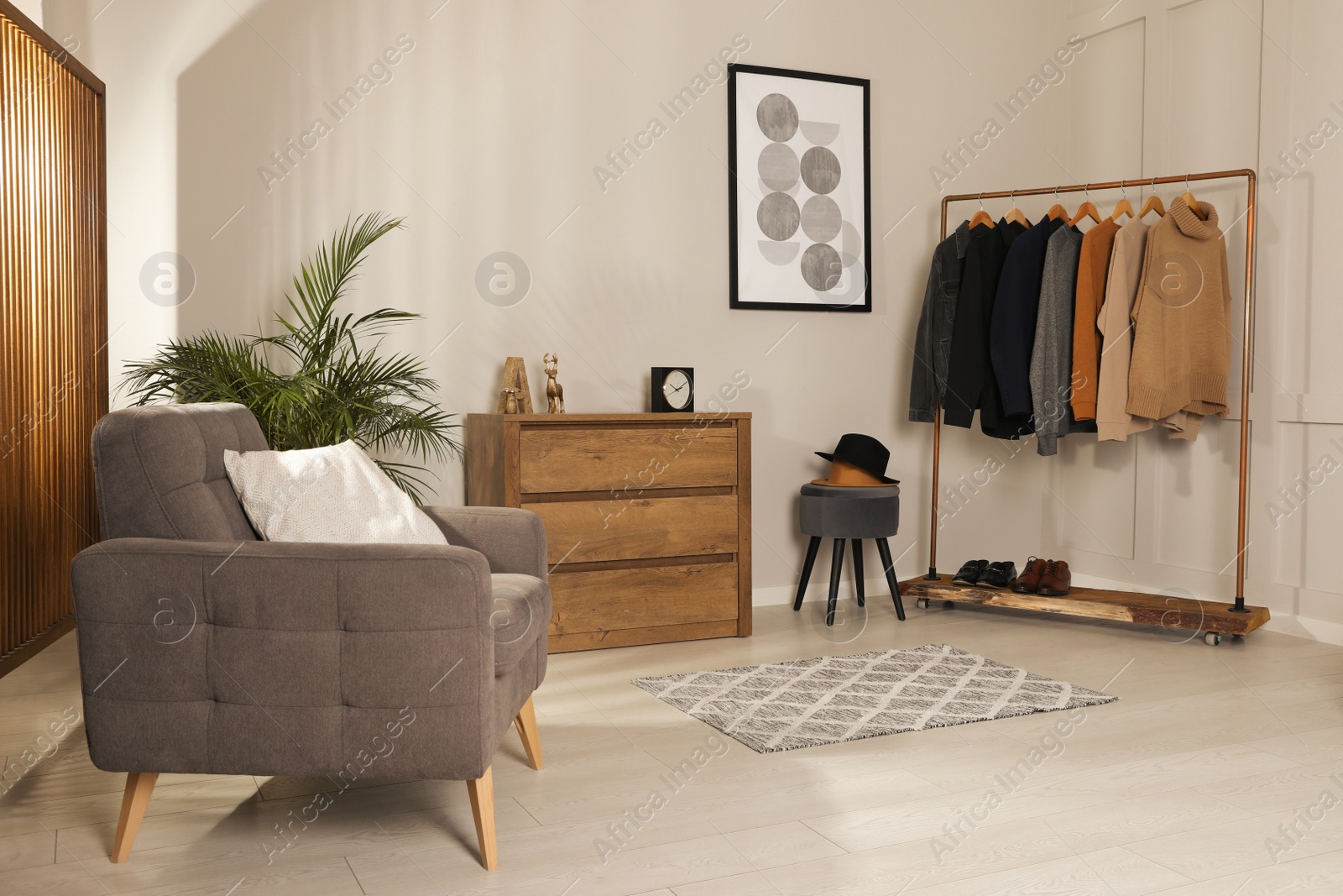 Photo of Modern dressing room interior with stylish clothes, shoes and decorative elements