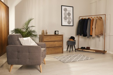 Photo of Modern dressing room interior with stylish clothes, shoes and decorative elements