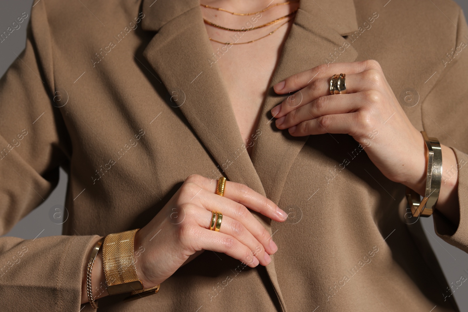 Photo of Beautiful woman with elegant jewelry on gray background, closeup