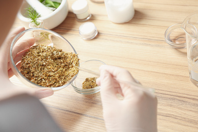 Scientist developing cosmetic product at wooden table in laboratory, closeup