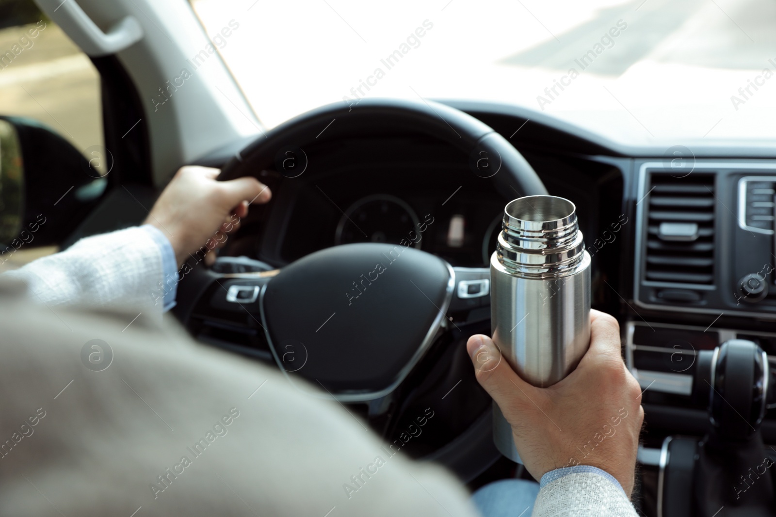 Photo of Man with thermos driving car, closeup view