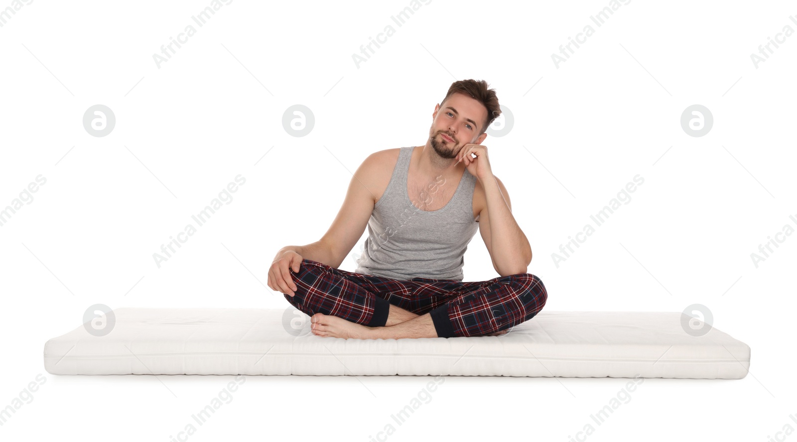 Photo of Man sitting on soft mattress against white background