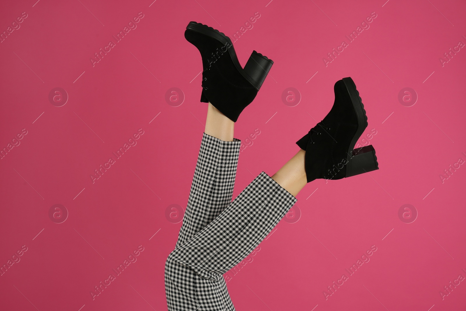 Photo of Woman wearing stylish boots on pink background, closeup