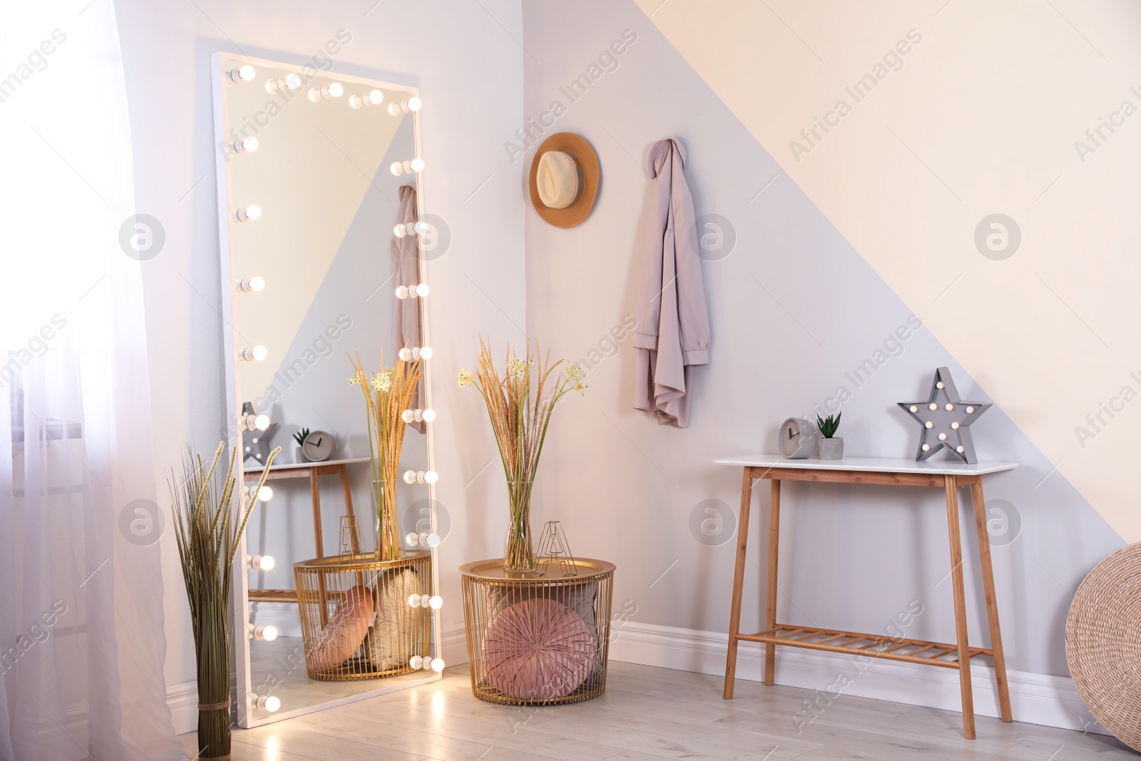 Photo of Large mirror with lamps in stylish room interior