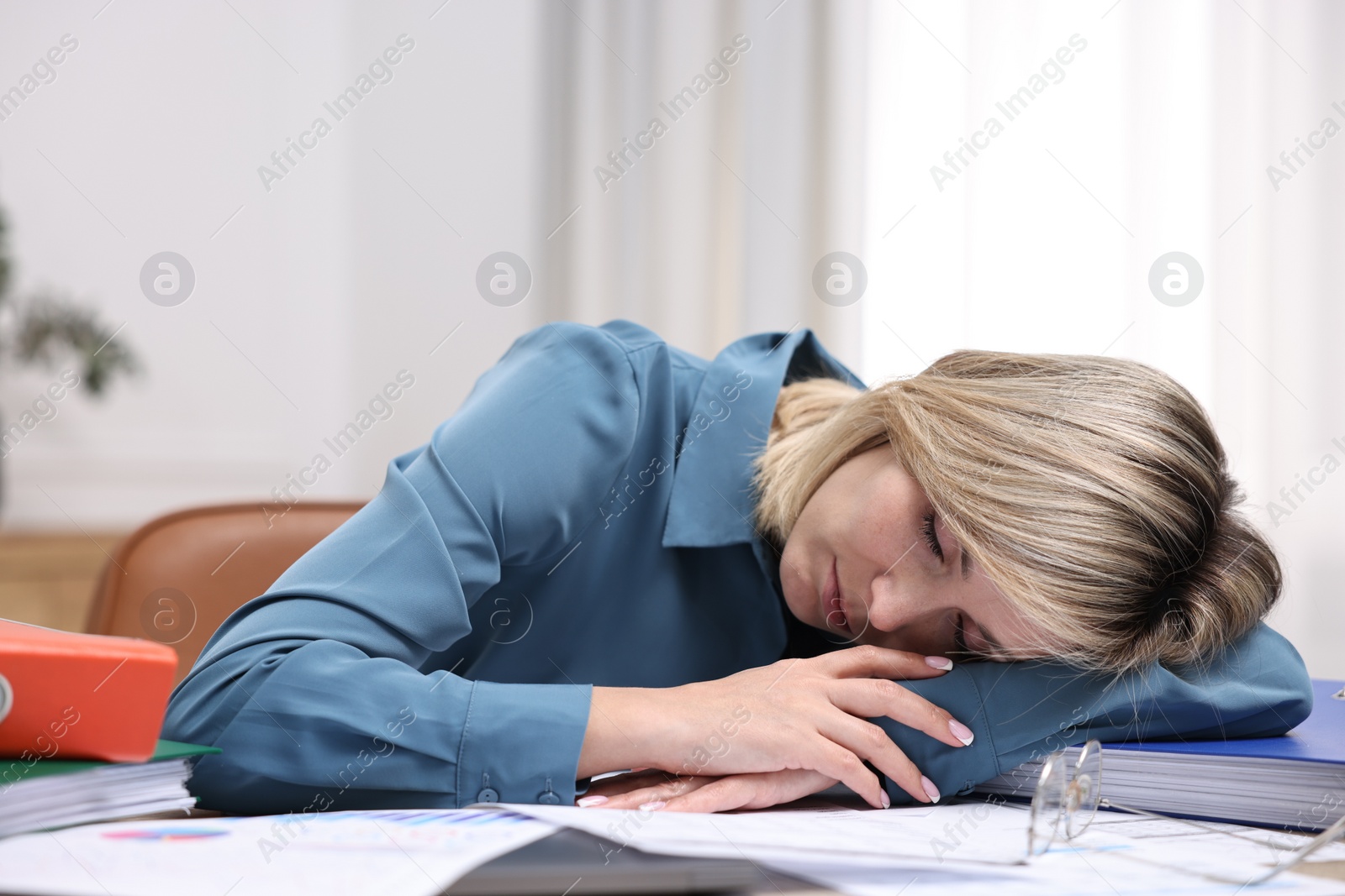 Photo of Office worker sleeping at workplace. Overwhelmed by work