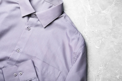 Photo of Stylish shirt on grey marble table, top view. Dry-cleaning service