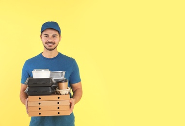 Photo of Young courier with different orders on color background, space for text. Food delivery service