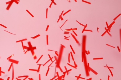 Photo of Shiny red confetti falling down on pink background