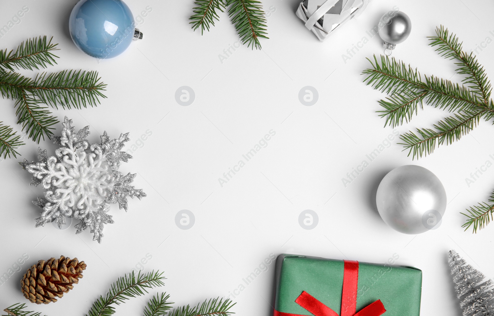 Photo of Christmas greeting card with space for text. Flat lay composition of fir tree branches and festive decor on white background