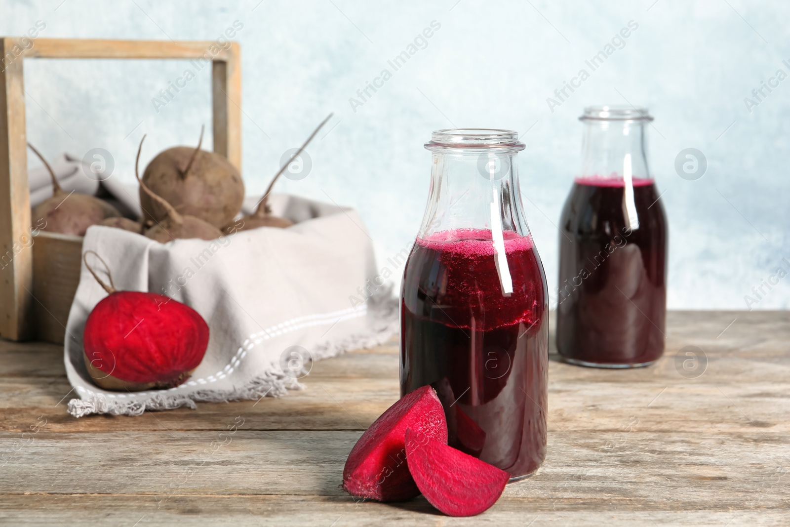 Photo of Bottle of beet smoothie on wooden table