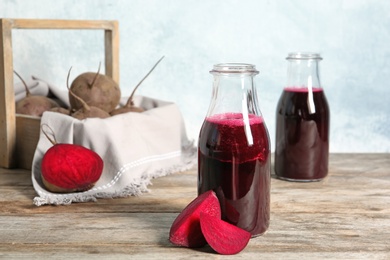 Photo of Bottle of beet smoothie on wooden table