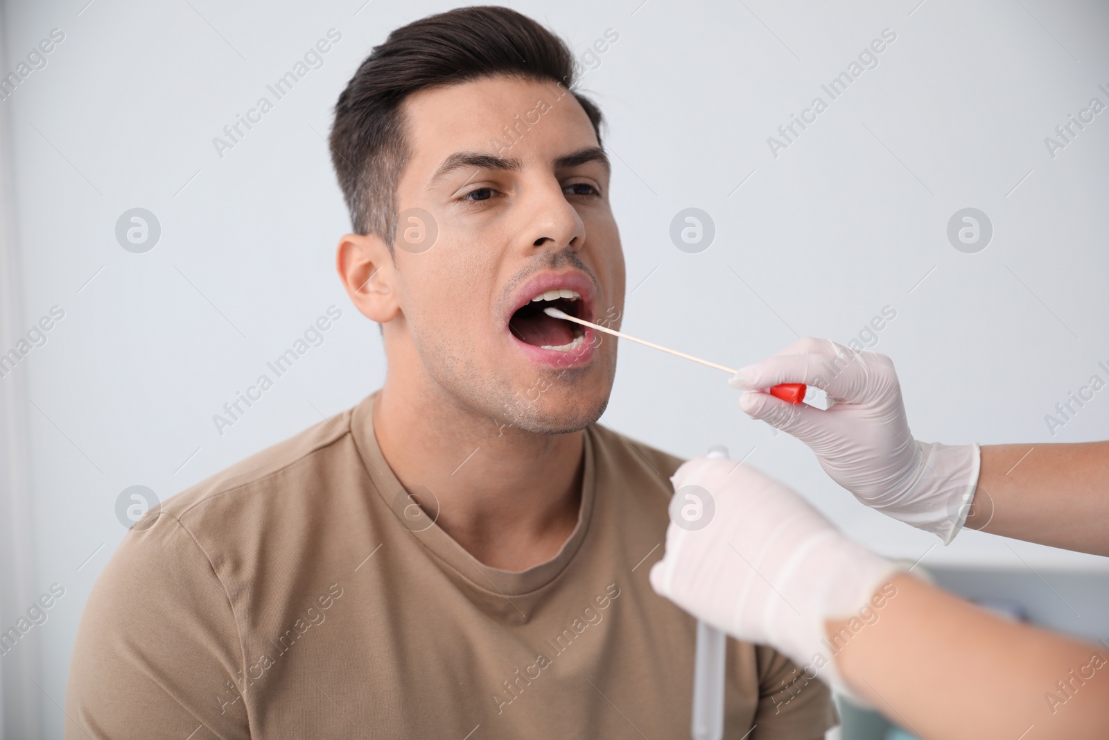 Photo of Doctor taking sample for DNA test from man in clinic