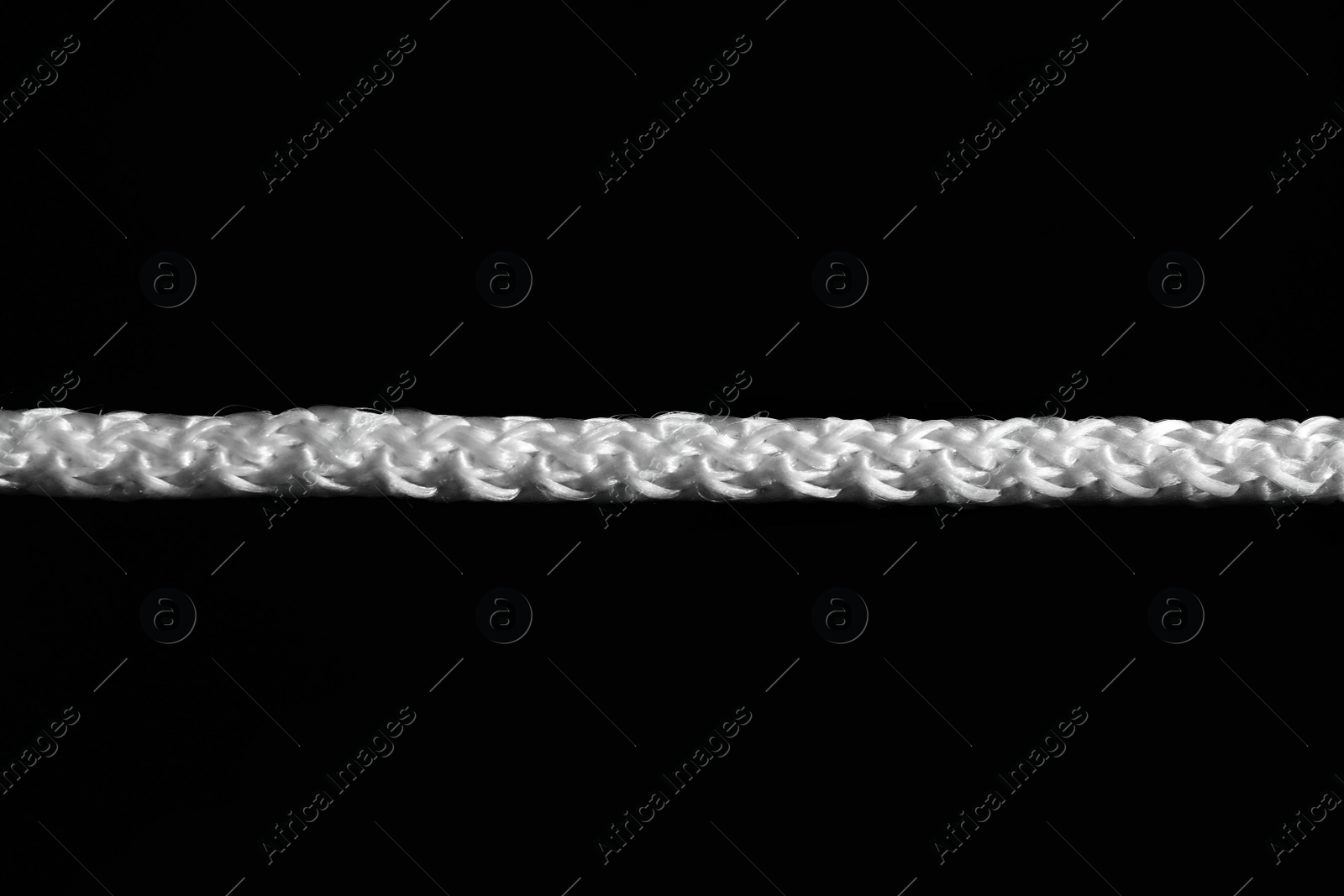 Photo of Strong straight white rope on black background