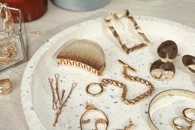 Photo of Stylish golden bijouterie and hair accessories on table, closeup