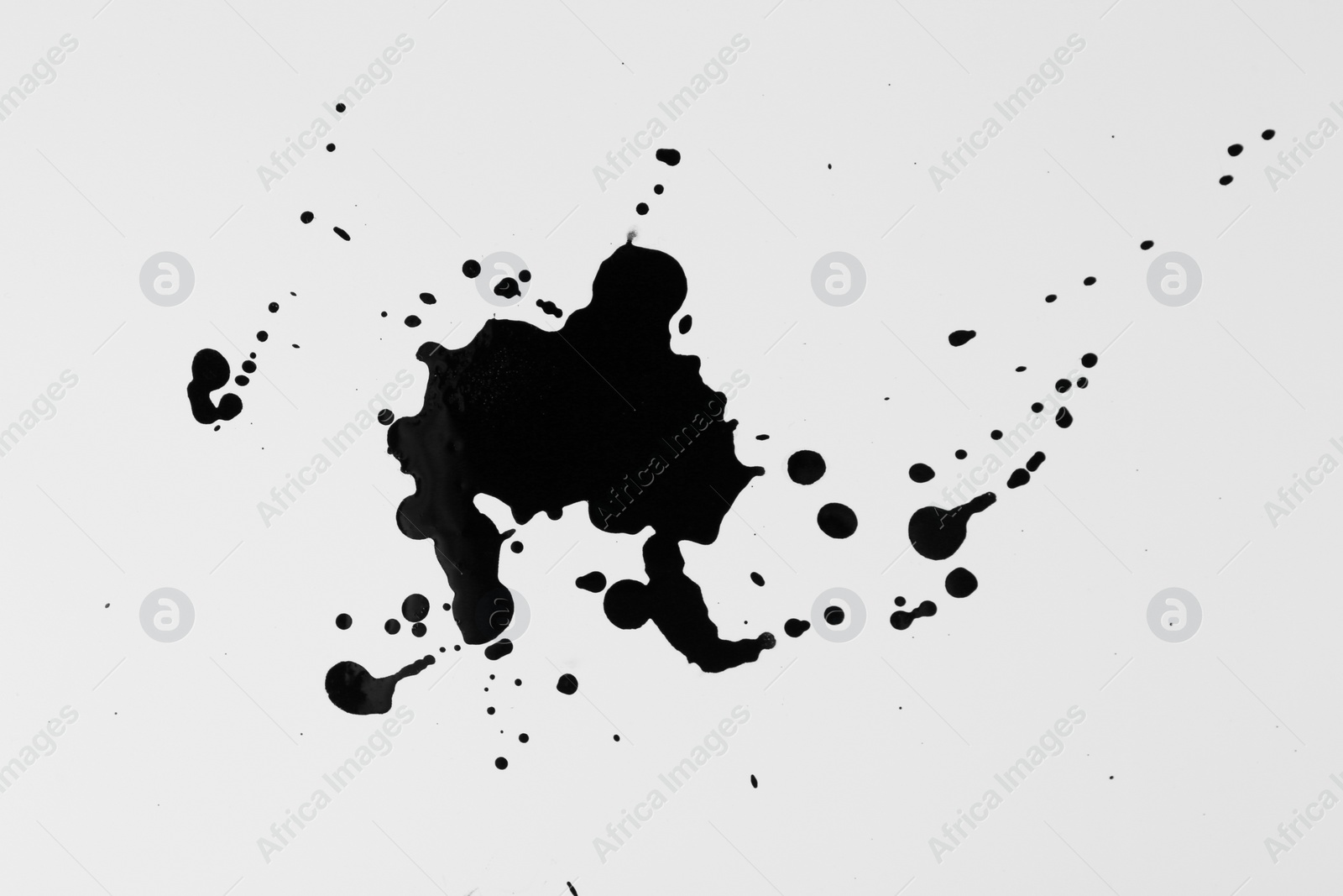 Photo of Blots of black ink on white background, top view