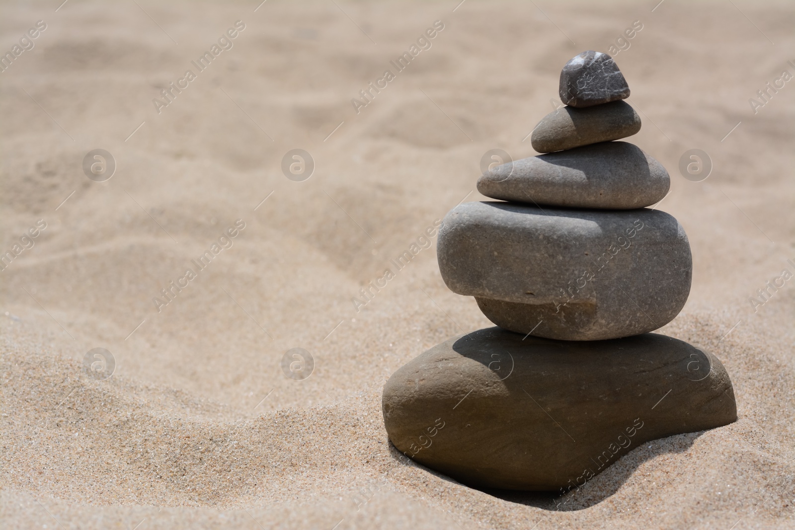 Photo of Stack of stones on beautiful sandy beach, space for text