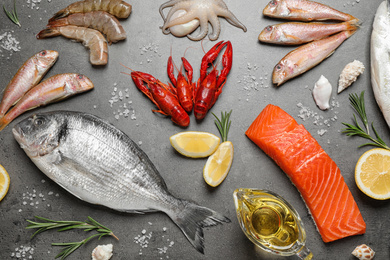 Photo of Fresh fish and seafood on grey table, flat lay