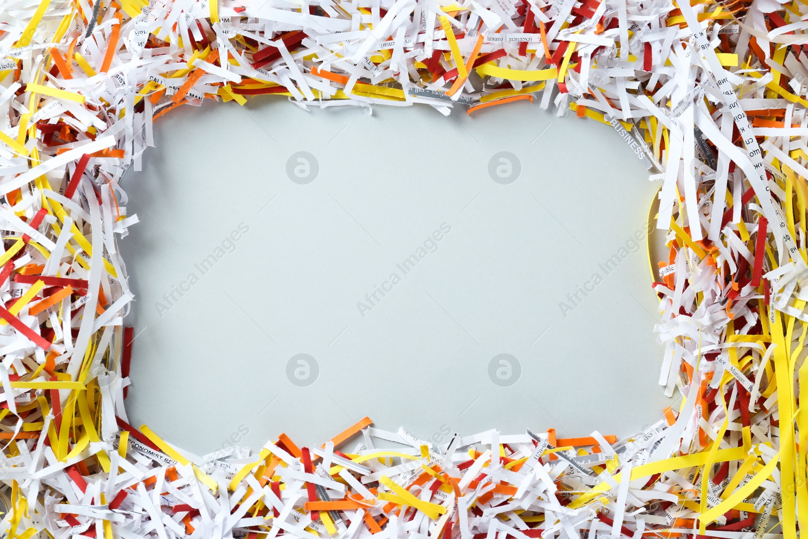 Photo of Frame of shredded colorful paper strips on white background, flat lay. Space for text