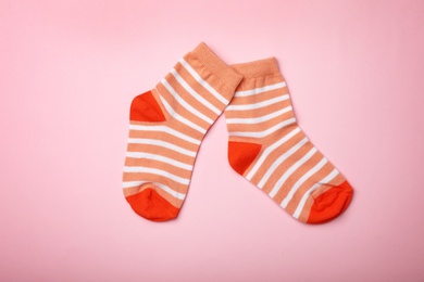 Photo of Cute child socks on color background, flat lay