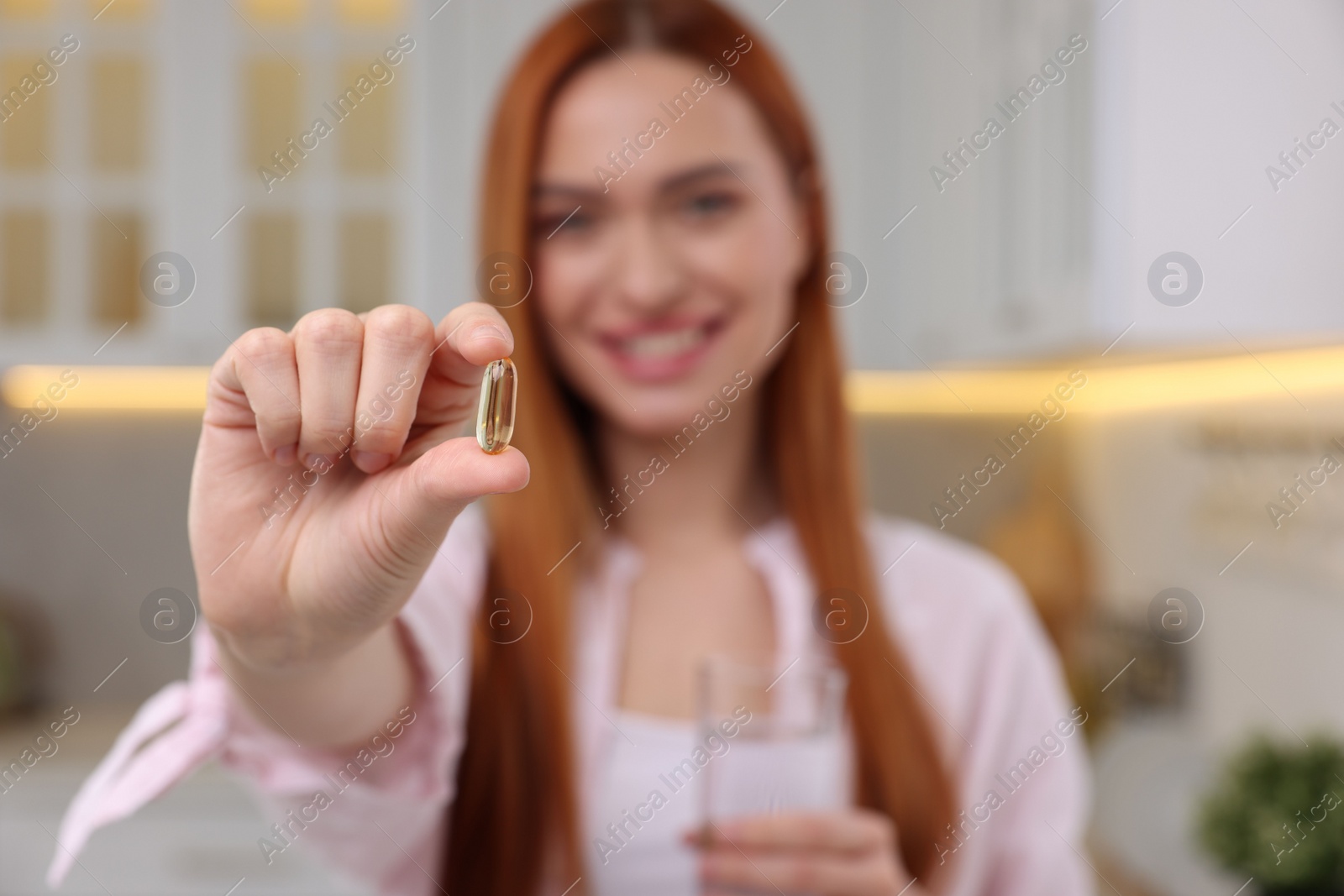 Photo of Beautiful young woman with vitamin pill and glass of water, selective focus