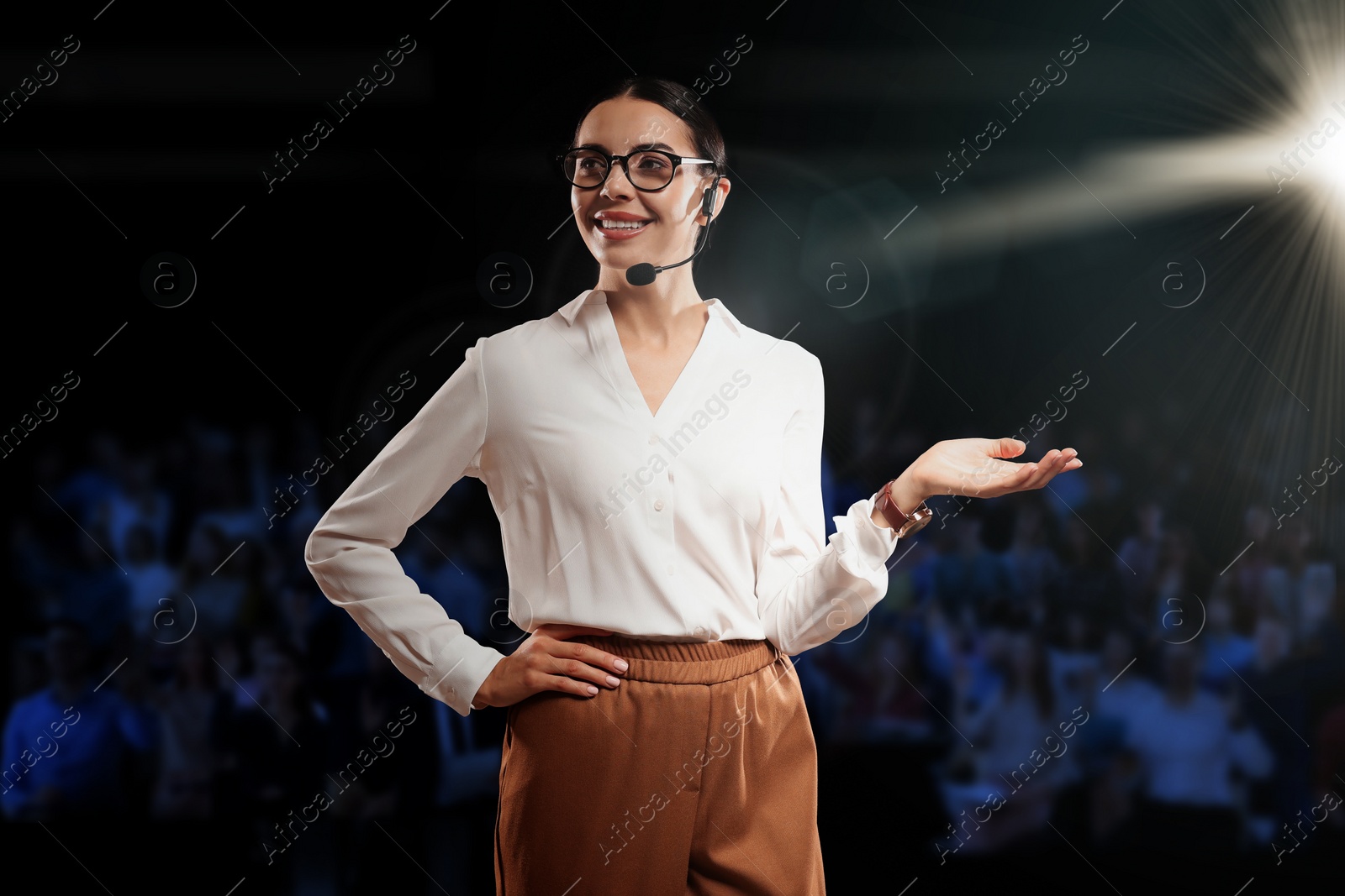 Image of Motivational speaker with headset performing on stage