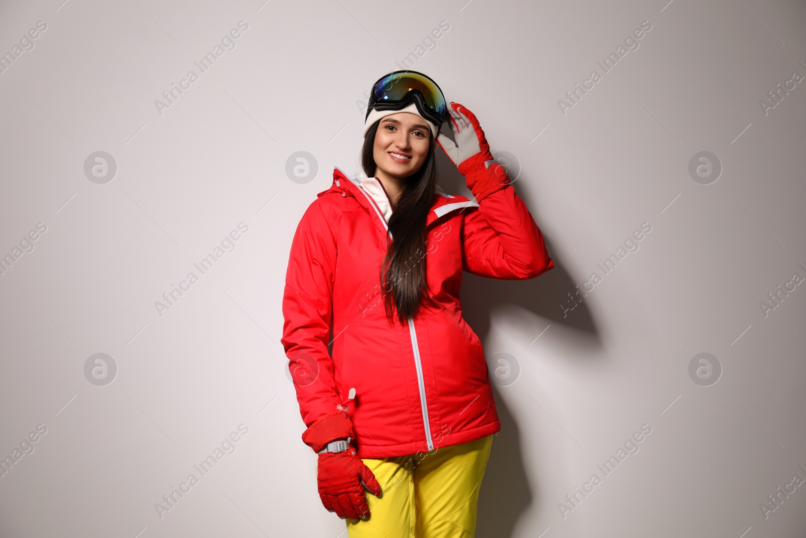 Photo of Woman wearing stylish winter sport clothes on light grey background