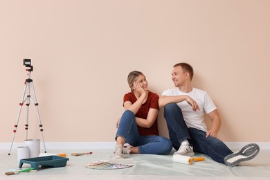 Photo of Happy couple discussing interior details in apartment during repair
