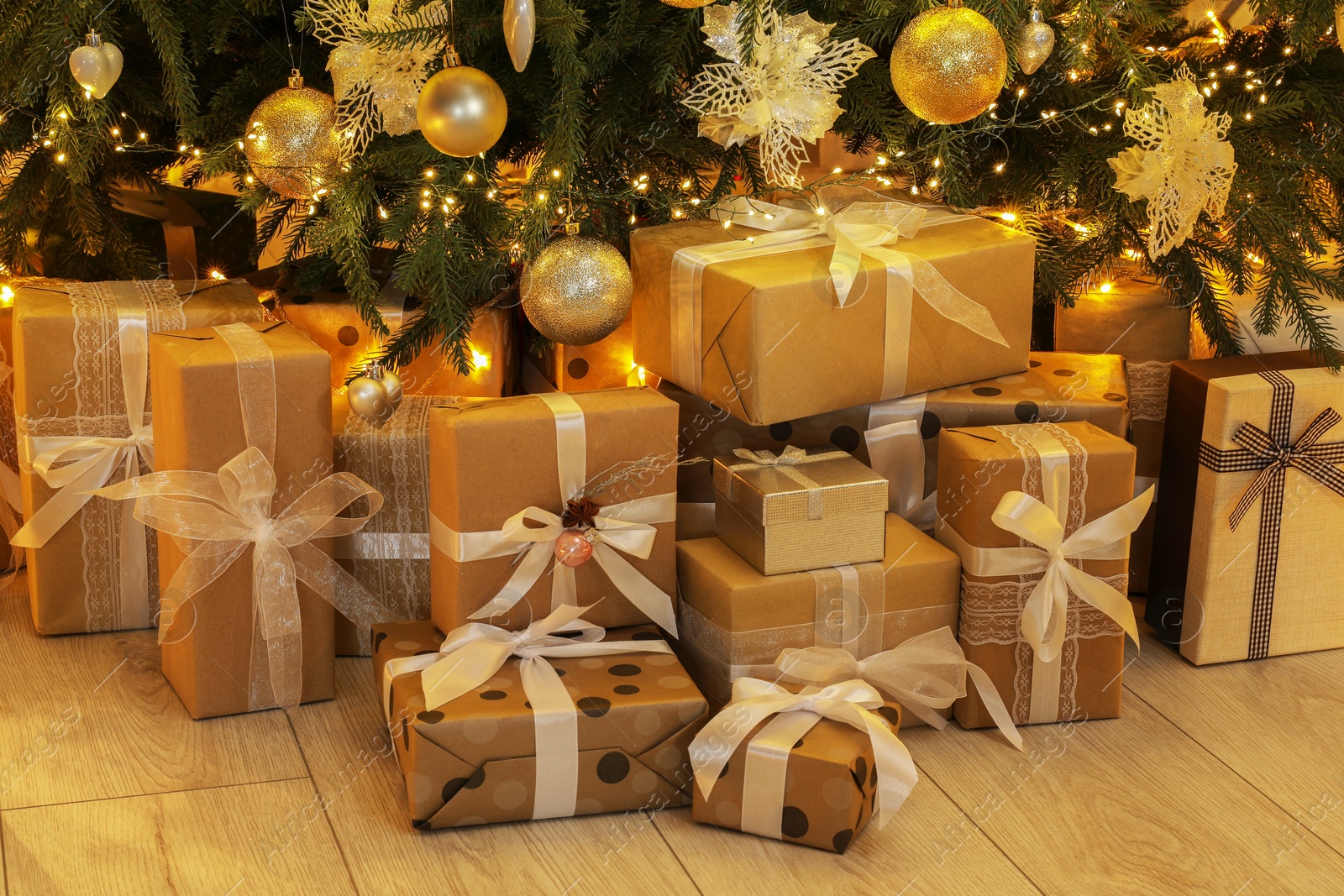 Photo of Many gift boxes under decorated Christmas tree at home