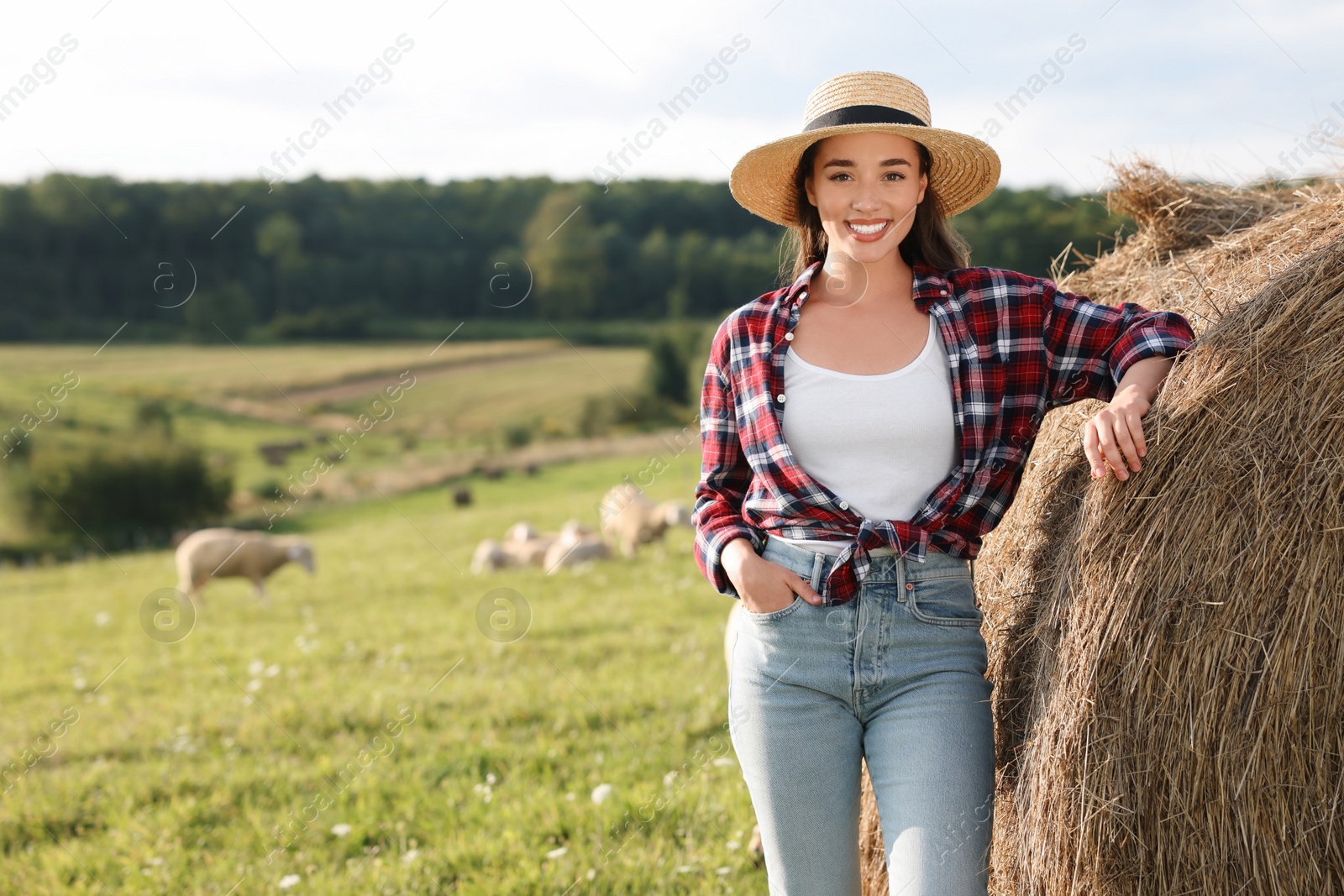 Photo of Smiling farmer near hay bale outdoors. Space for text