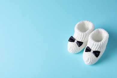 Handmade baby booties on color background. Space for text