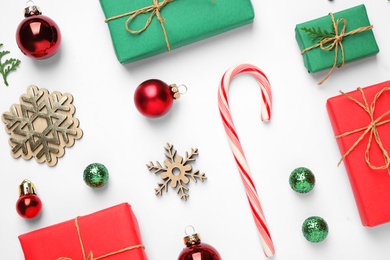 Flat lay composition with Christmas gifts and festive decor on white background