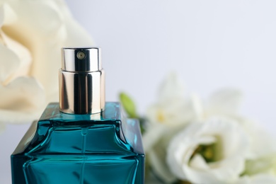 Photo of Bottle of perfume on blurred background, closeup. Space for text