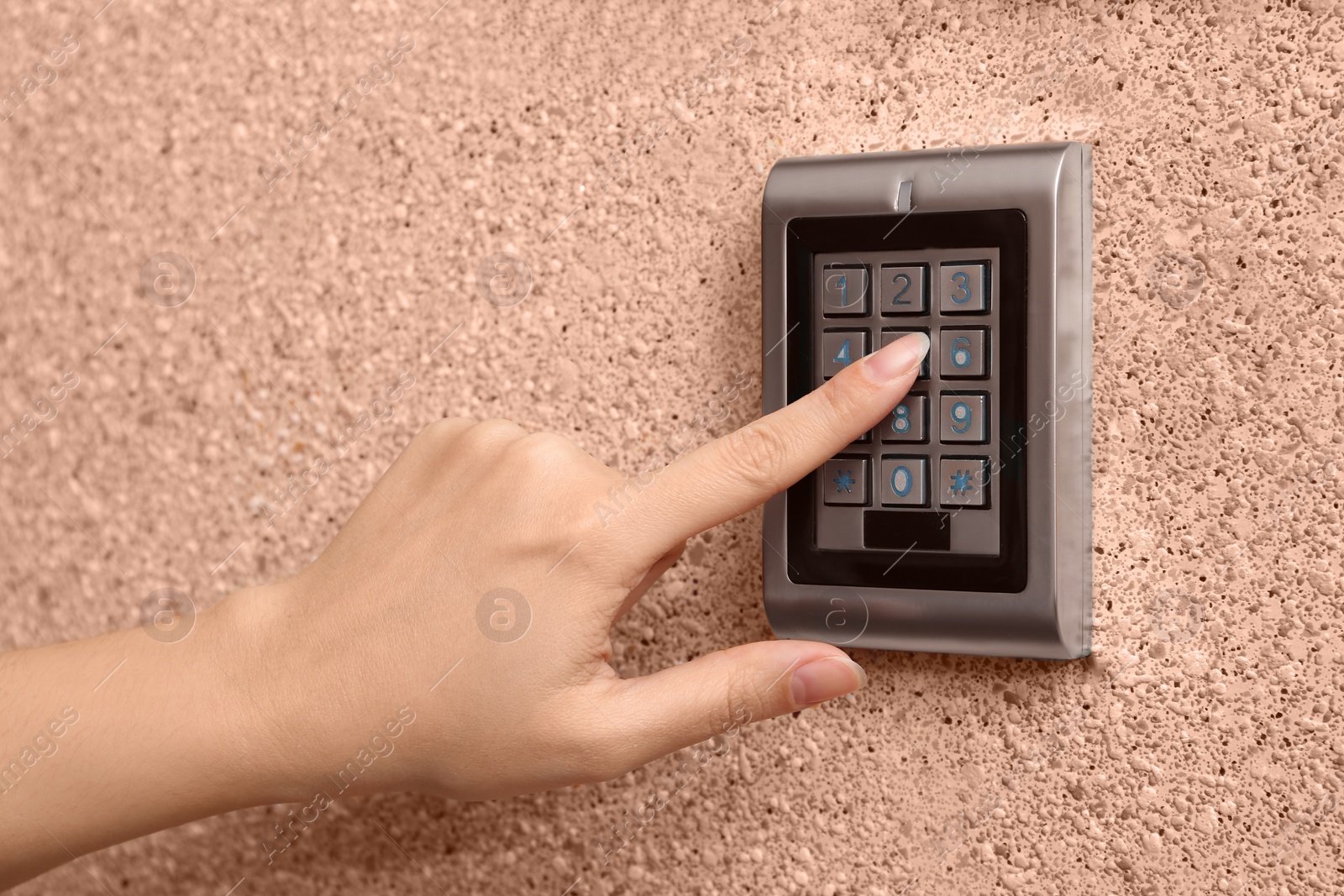 Photo of Woman entering code on electronic lock's keypad indoors, closeup