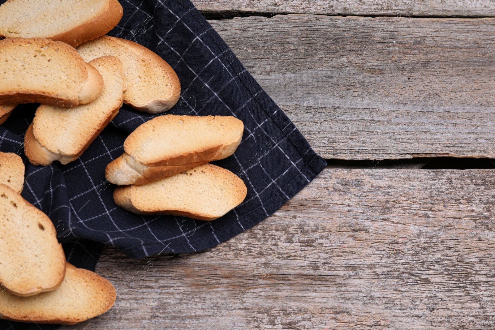 Photo of Tasty hard chuck crackers on wooden table, flat lay. Space for text