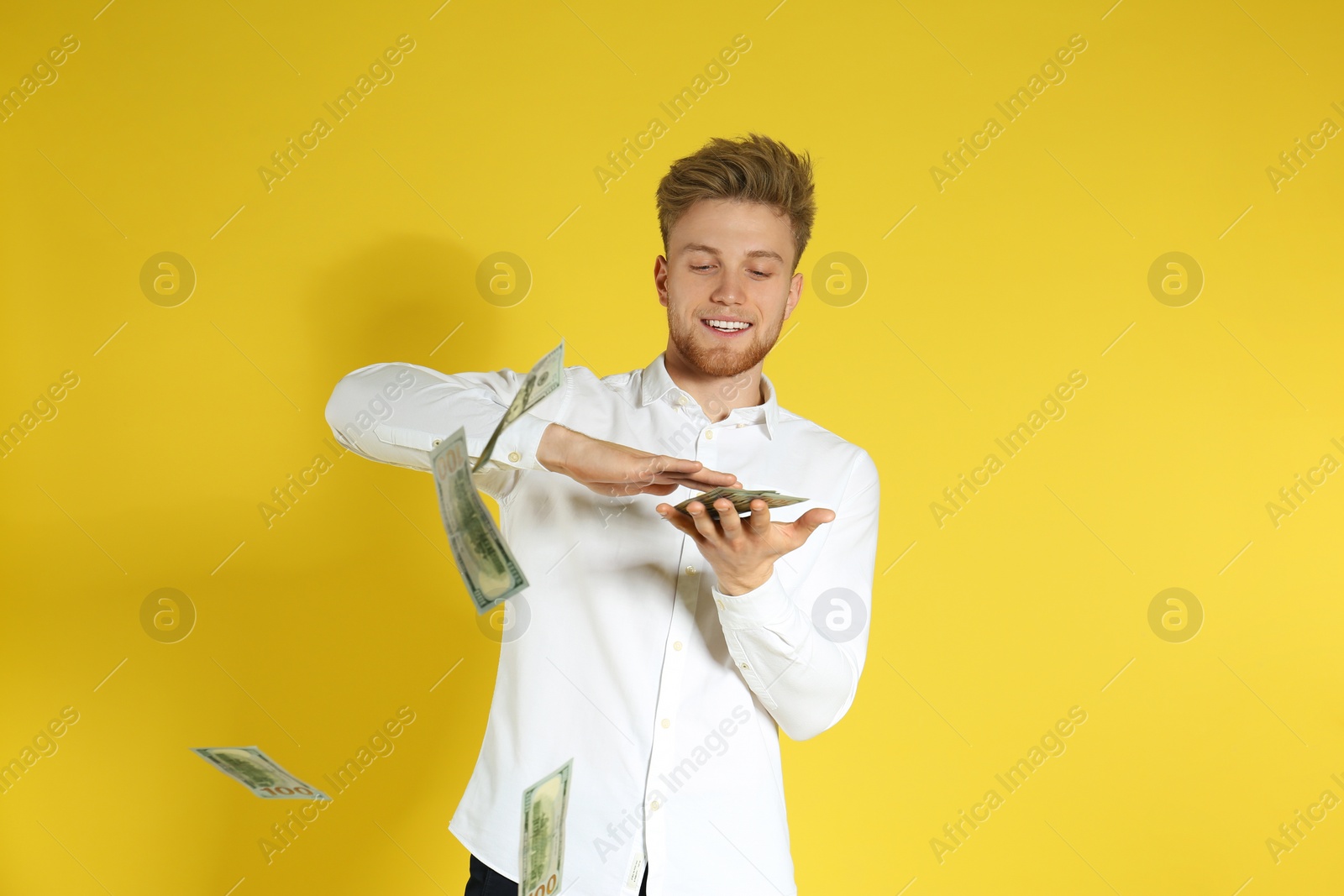 Photo of Young man throwing money on color background