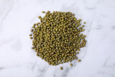 Photo of Pile of green mung beans on white marble table, top view
