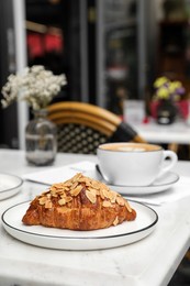 Photo of Delicious croissant and coffee on white marble table