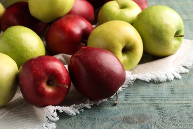 Fresh ripe red and green apples on light blue wooden table, closeup