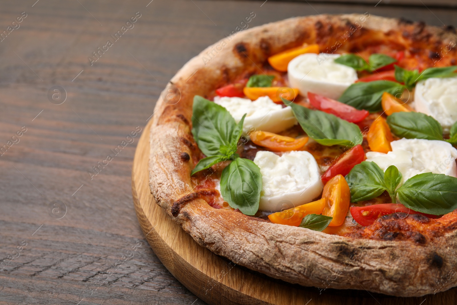 Photo of Delicious pizza with burrata cheese, tomatoes and basil on wooden table, closeup. Space for text